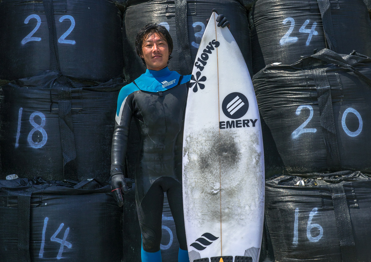 Japanese surfer in front of bags with contaminated sand after the daiichi nuclear power plant irradiation, Fukushima prefecture, Tairatoyoma beach, Japan